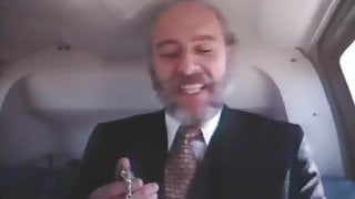 Old bearded man in a suit getting head in a helicopter